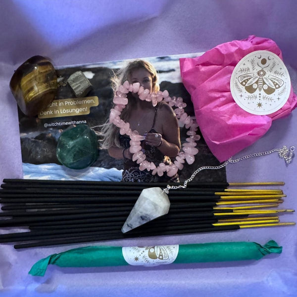 Inhalt der Mystery Box mit Kristallen, Teelicht, Schmuck, Pendel und Räucherwerk